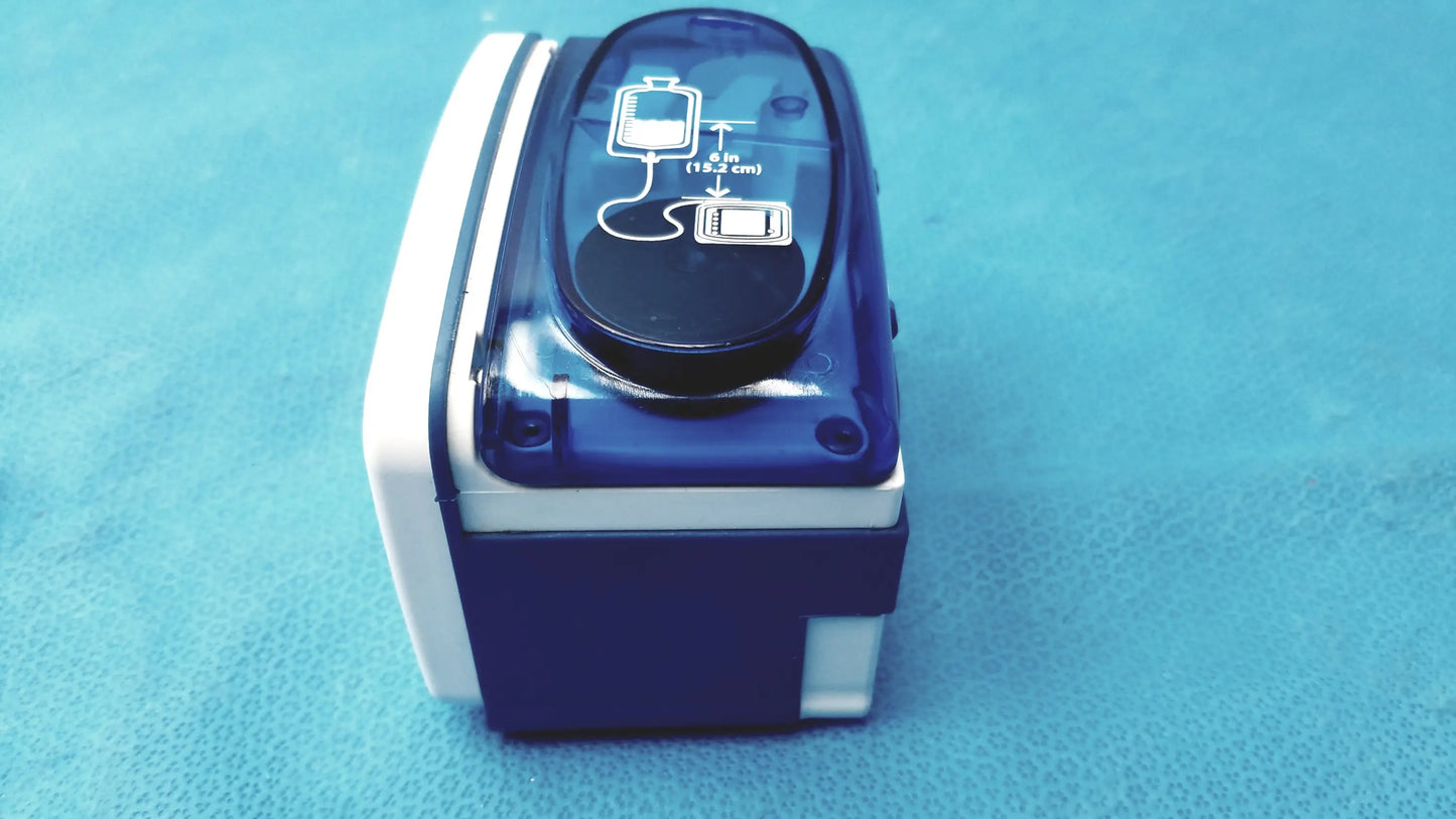 Blue and white portable blood pressure monitor with transparent top panel displaying diagrams and kangaroo joey pole clamp flush pump