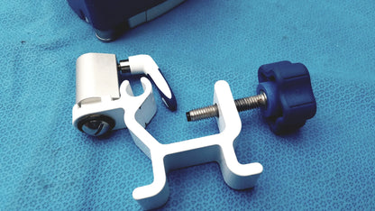 White plastic surgical instrument holder with blue knob and metallic screw for kangaroo joey flush pump pole clamp