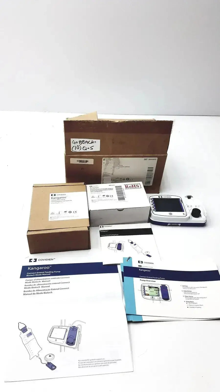 White and blue covidien kangroo feeding pump with small screen control buttons and pole clamp for patient monitoring