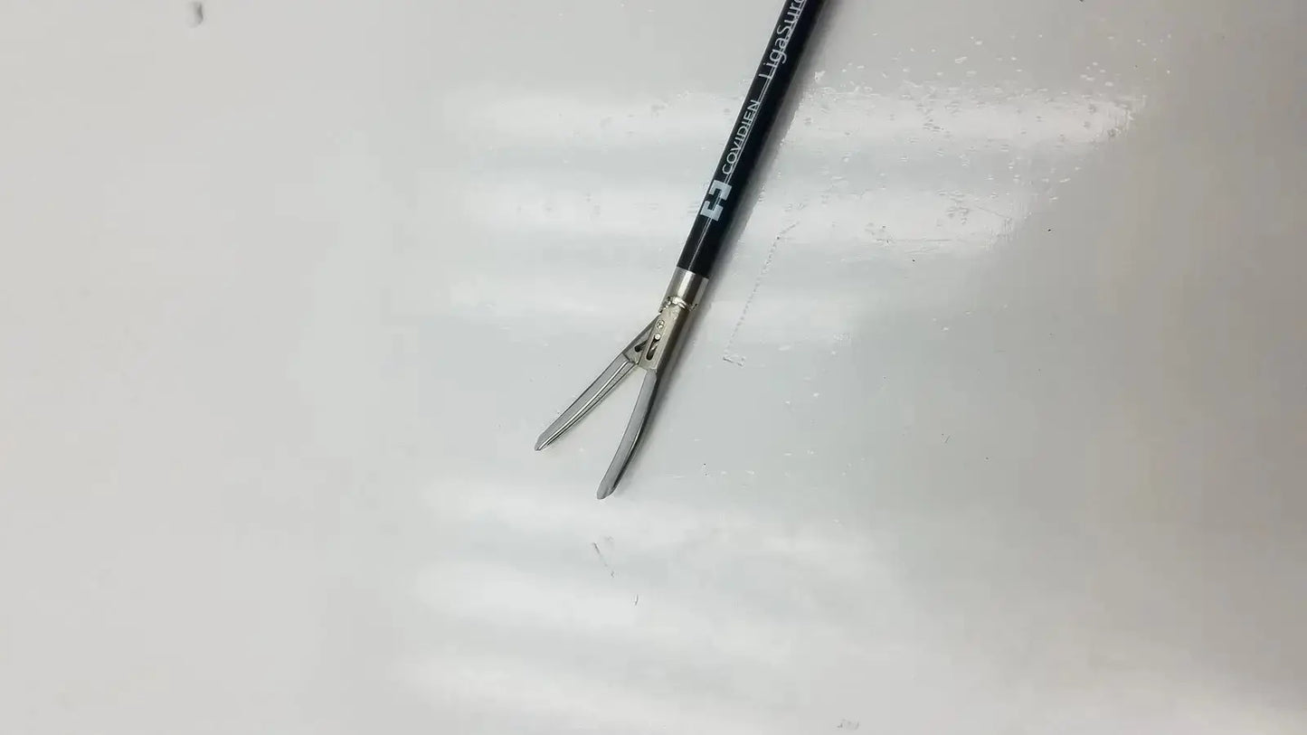 Black-handled covidien ligasure maryland jaw sealer divider 5mm 44cm with silver metallic jaws and branded shaft