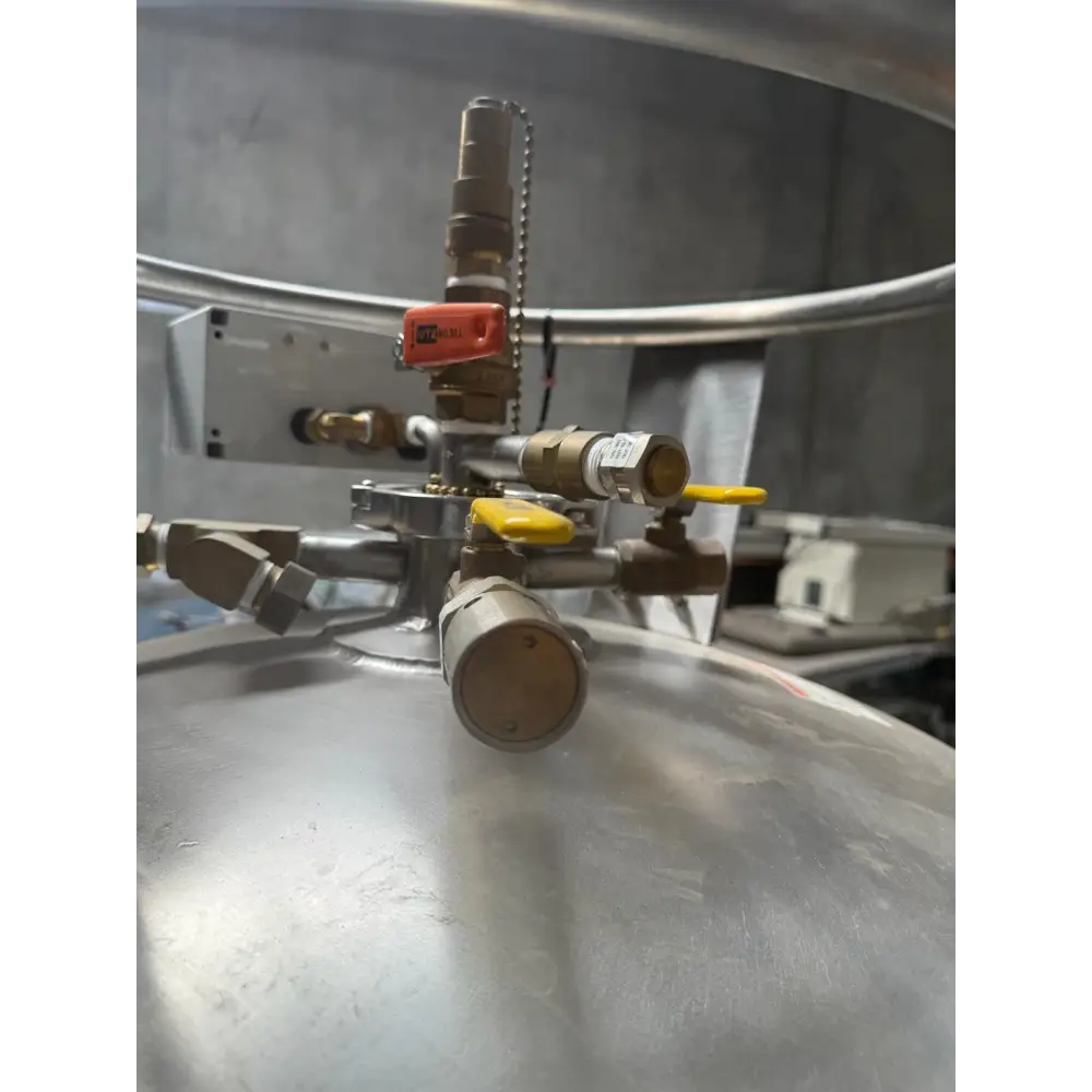 Industrial-grade stainless steel pressure vessel with brass fittings and bright yellow handles.