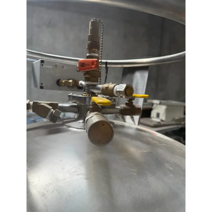 Industrial-grade stainless steel pressure vessel with brass fittings and bright yellow handles.