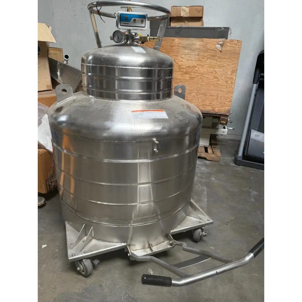 Stainless steel cryogenic tank with a blue control panel and black rubberized handle, mounted on a wheeled metal cart.