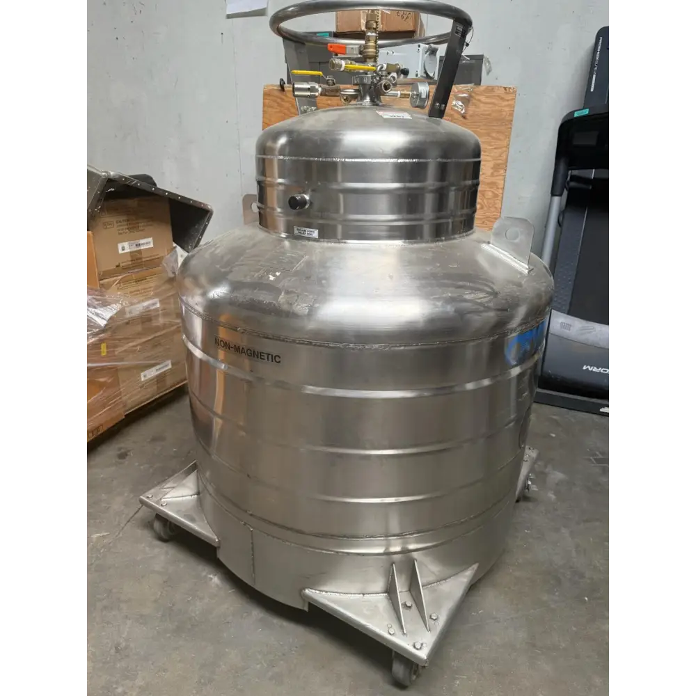 Silver stainless steel cryogenic tank with a rounded top and base, featuring horizontal ridges and mounted on casters.