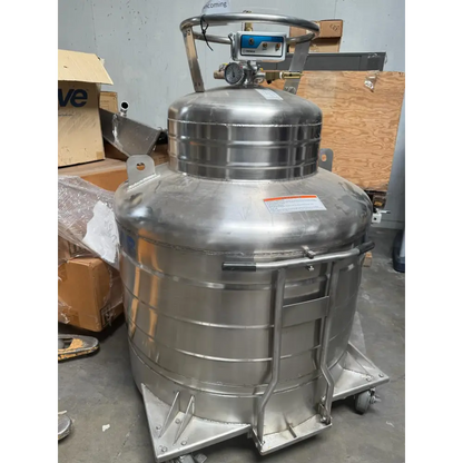 Stainless steel cryogenic tank with a blue and silver control panel, pressure gauge, and safety valves mounted on top.