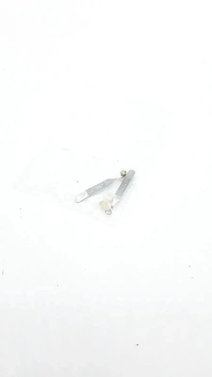Silver metal tool with flat handle and small circular end used for damaged teeth portrait ipn c1 p21 examination