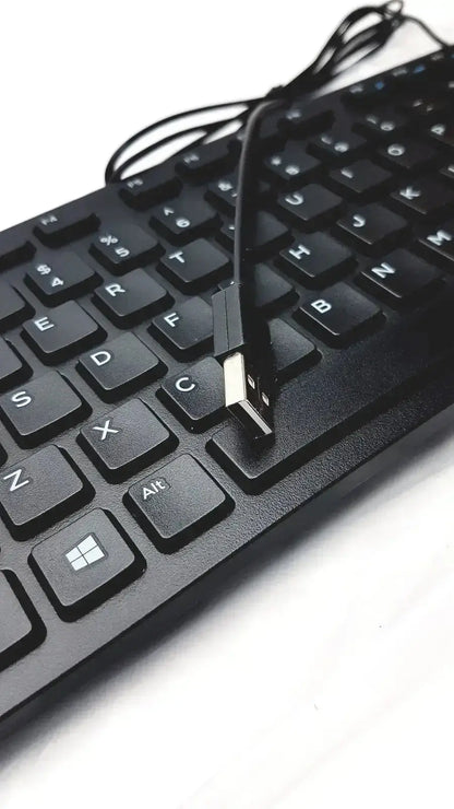 Black usb-a to usb-b cable resting on a matte black dell kb216-bk-us wired keyboard with white lettering keys