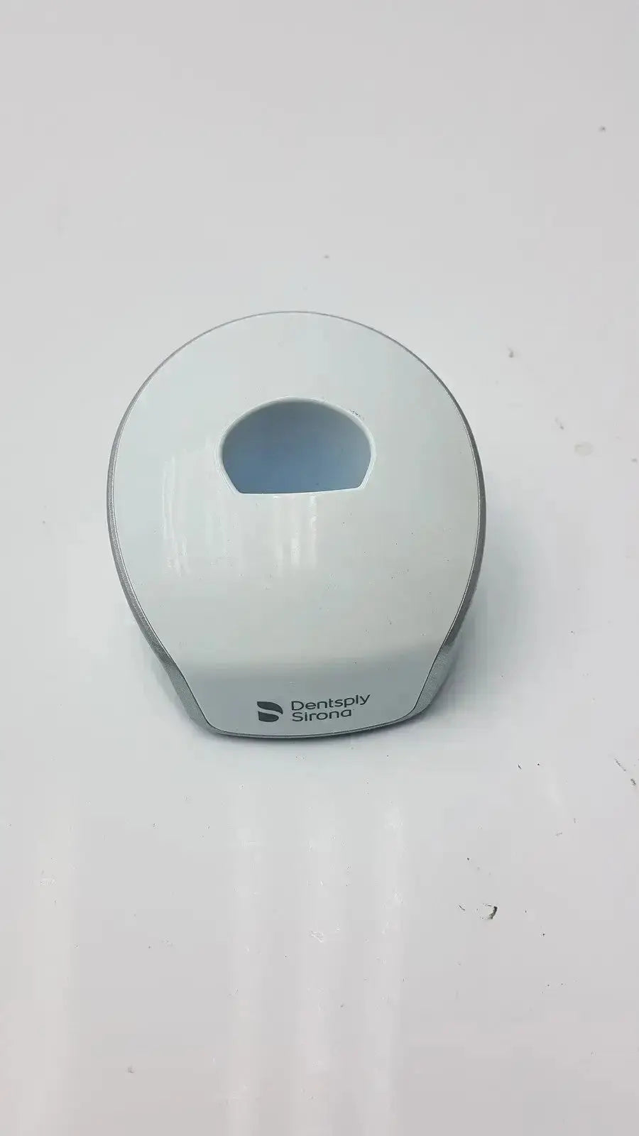 White and gray dentsply sirona smartlite focus curing light charger base with smooth rounded design for dental use