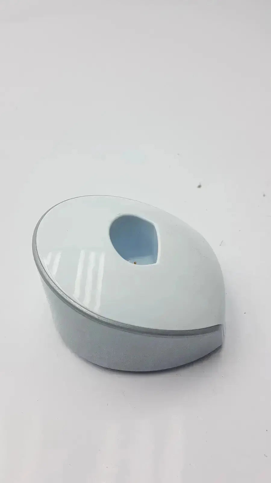 A sleek light gray plastic dentsply sirona smartlite focus curing light charger dock with oval cable cutout