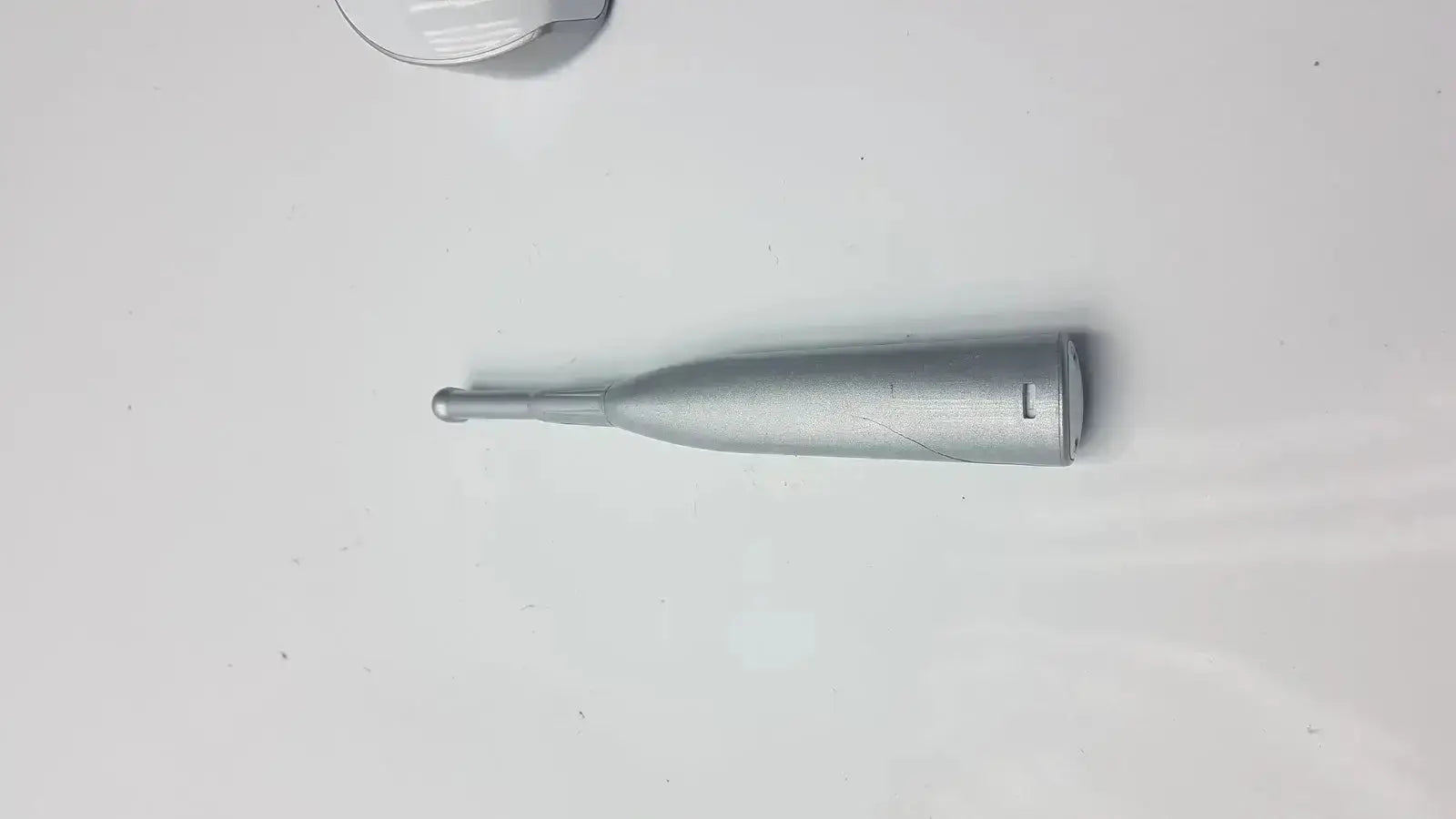 Silver metallic cylindrical dental curing light with rounded tip and rectangular cutout for dental curing use by dentsply sirona