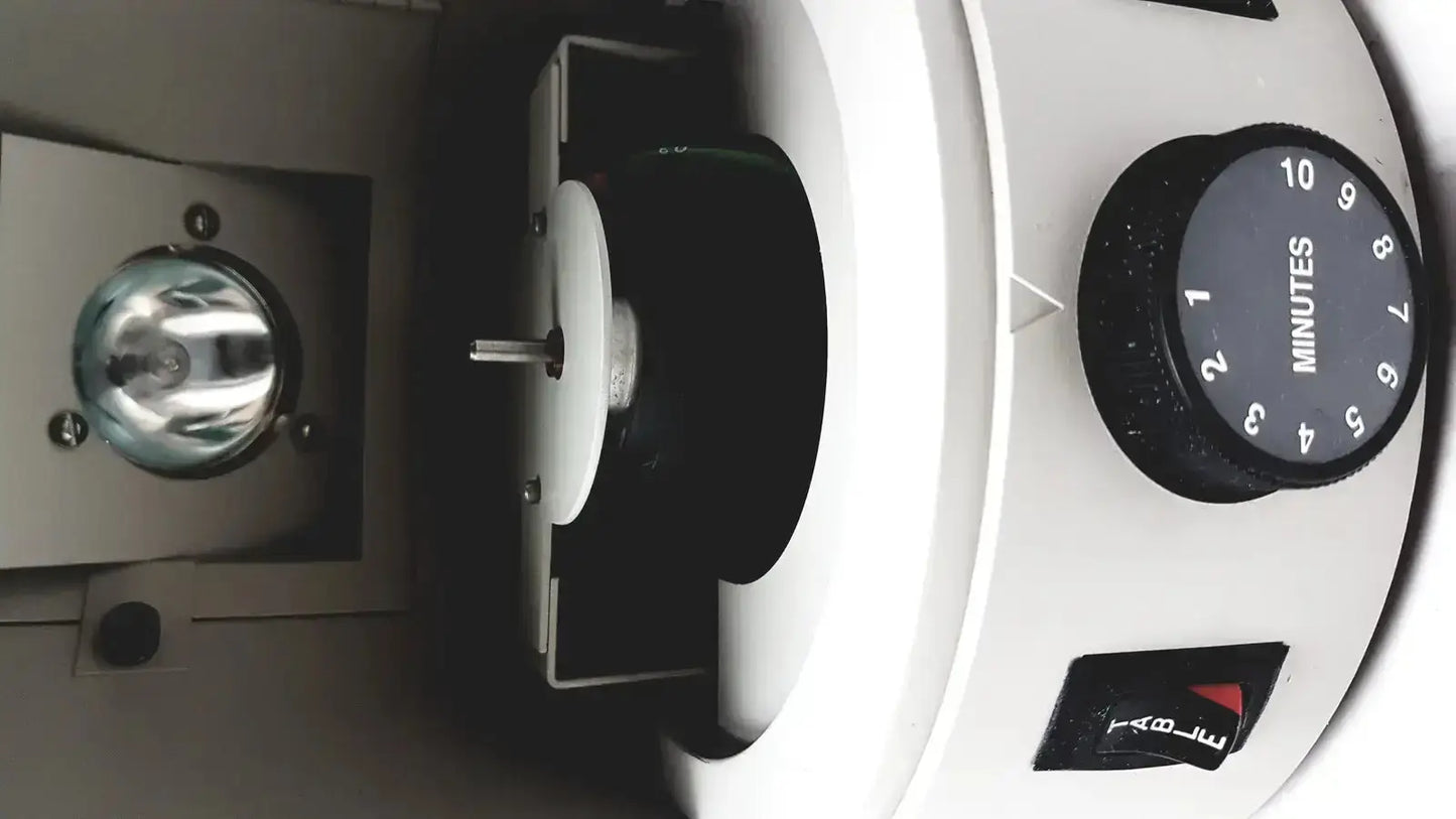 White laboratory centrifuge with black rotary timer dial and red black power switch for dentsply triad visible light cure system