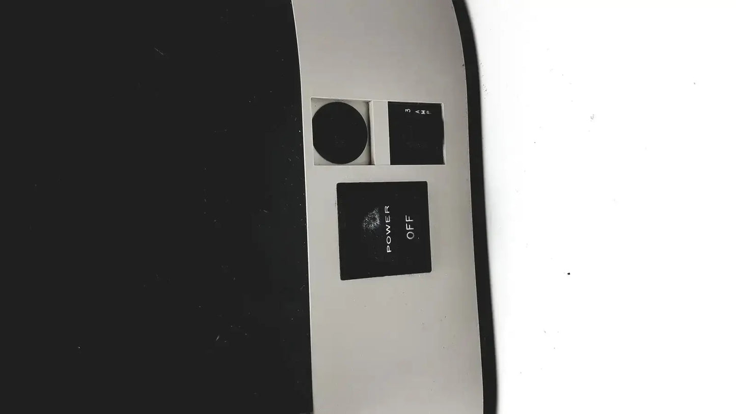 Black power button with white power off label on the curved surface of dentsply triad 2000 visible light cure system