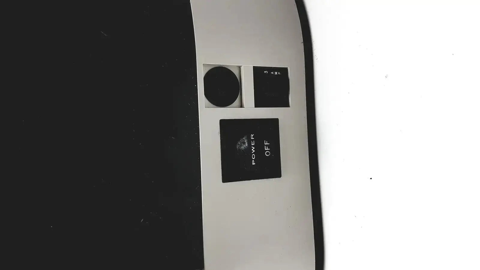 Black power button with white power off label on the curved surface of dentsply triad 2000 visible light cure system