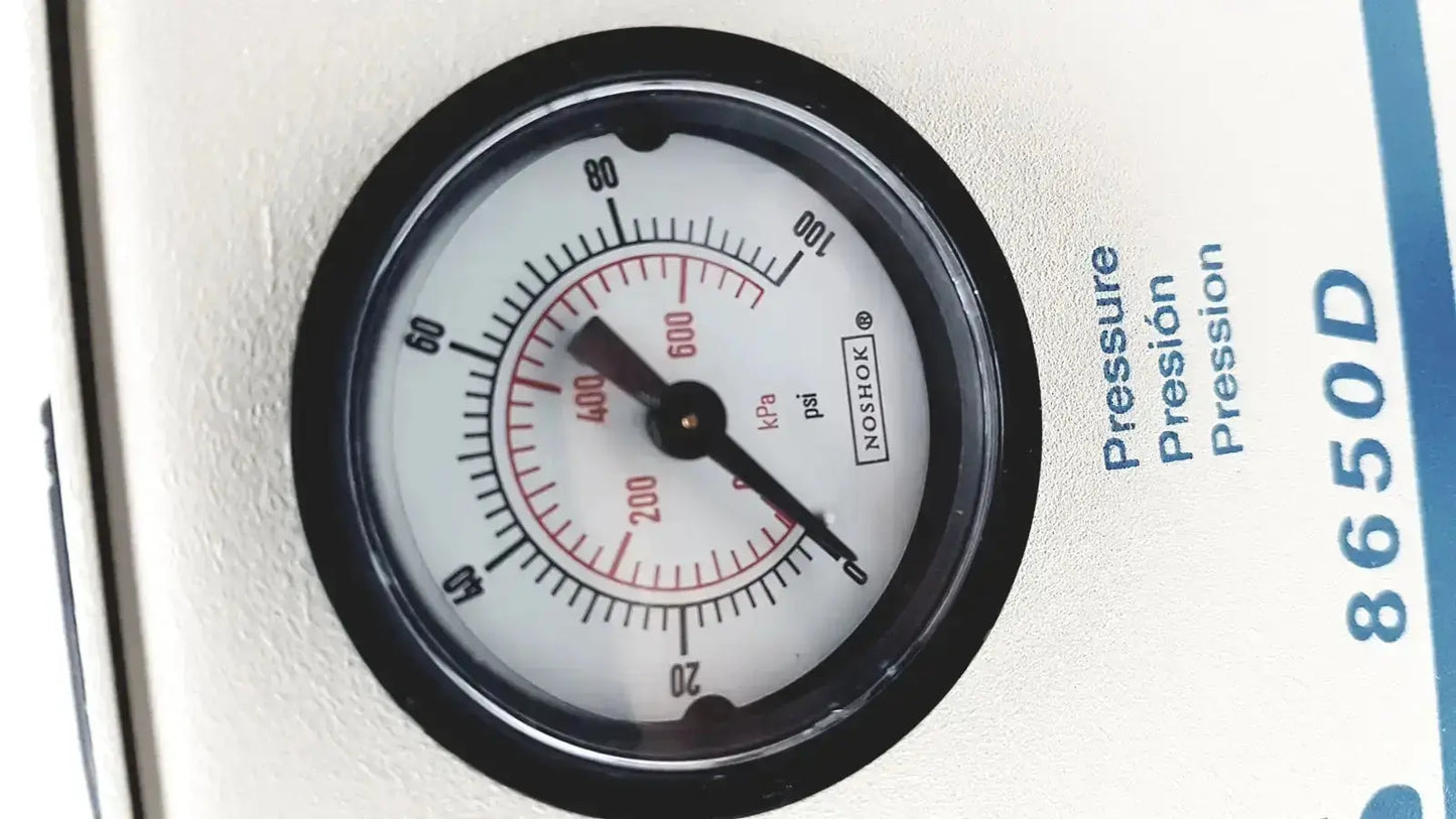Black-rimmed circular pressure gauge with white face and noshok branding on heavy duty devilbiiss aerosol compressor 8650d