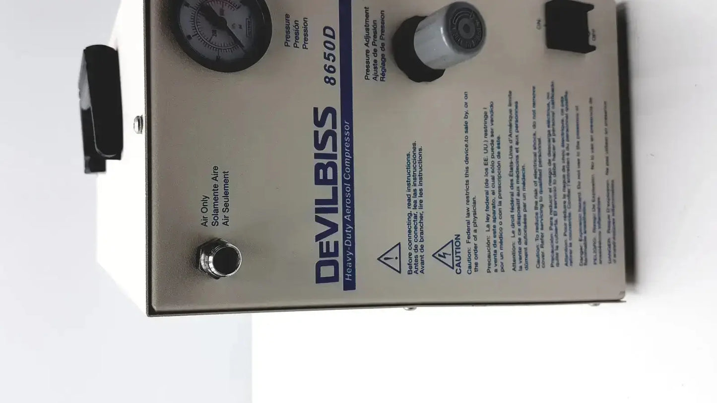 Silver metal heavy duty Devilbiss aerosol compressor model 8650d with black pressure gauge and control knobs for medical use