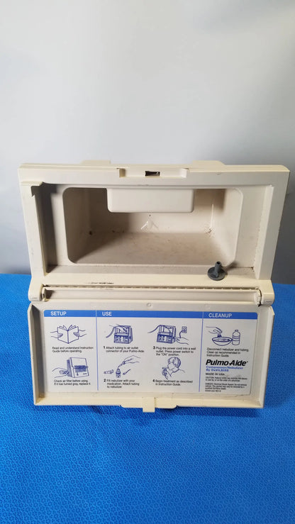 Beige plastic case of DeVilbiss 5650D pulmo-Aide compressor nebulizer system showing instructional diagrams reuse medical equipment