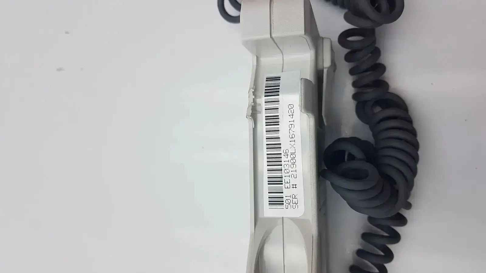 Gray plastic doppllex d900 handheld portable doppler with coiled black cable and barcode label visible on the back side