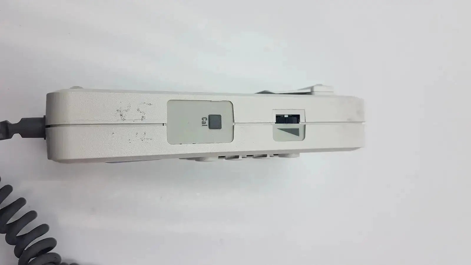 White plastic doppllex d900 handheld portable doppller with coiled black handset cable and visible buttons