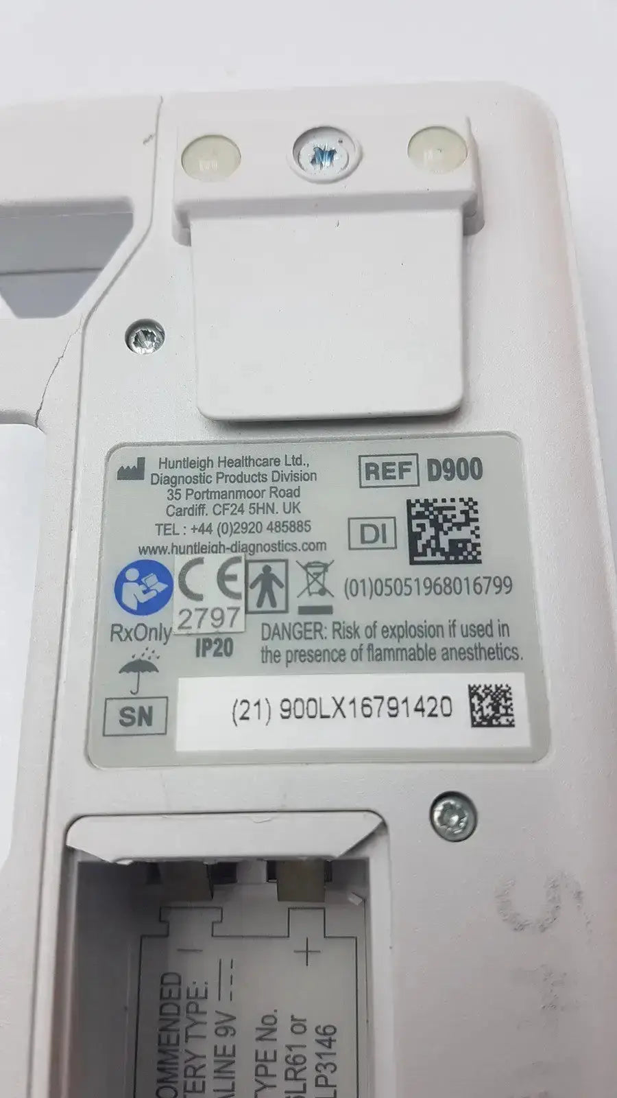 White plastic medical device with label and screws showing back side of doppllex d900 handheld portable doppller