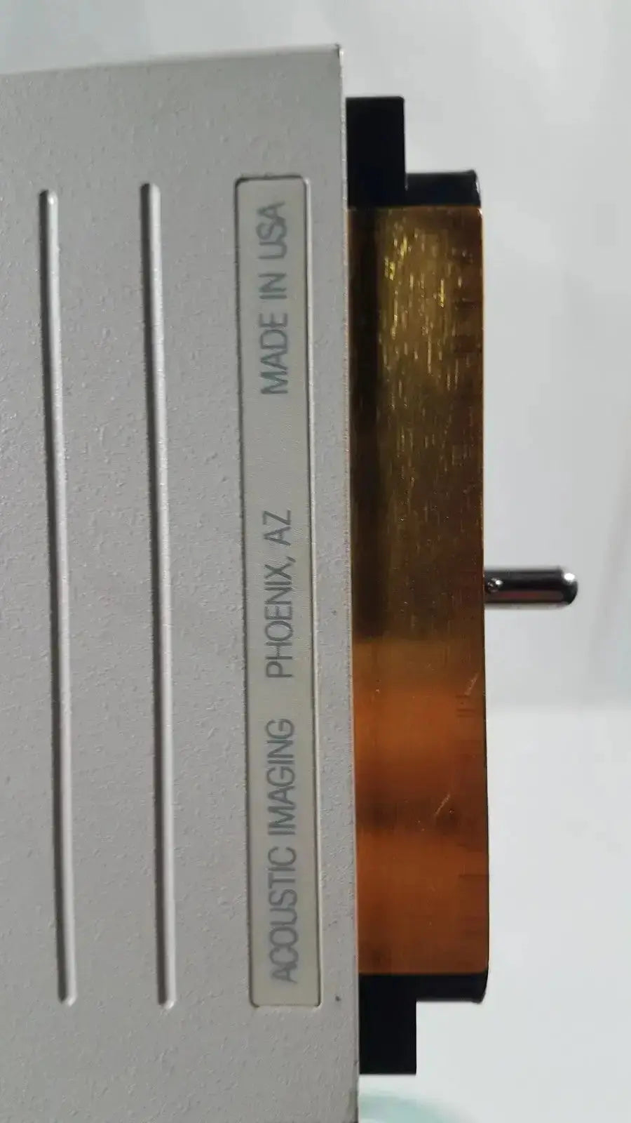 Silver metallic dornier curved array ultrasound transducer with vertical slots and amber flexible circuit board shown from back side
