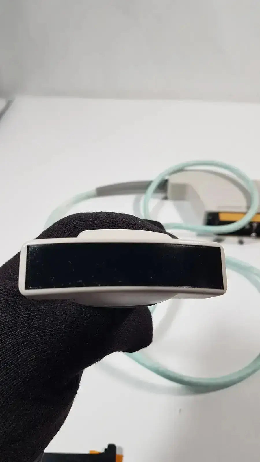 White handheld Dornier acoustic imaging curved array ultrasound transducer with black rectangular sensor face