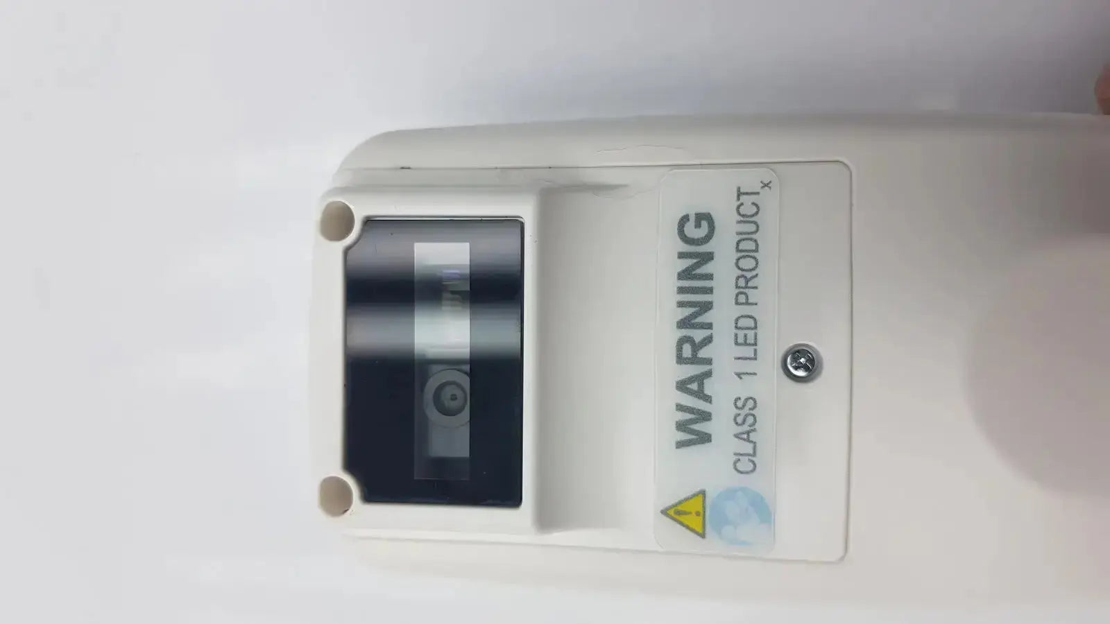 White plastic led light fixture with black rectangular lens and warning label on the back of drager jaundice meter jm-105