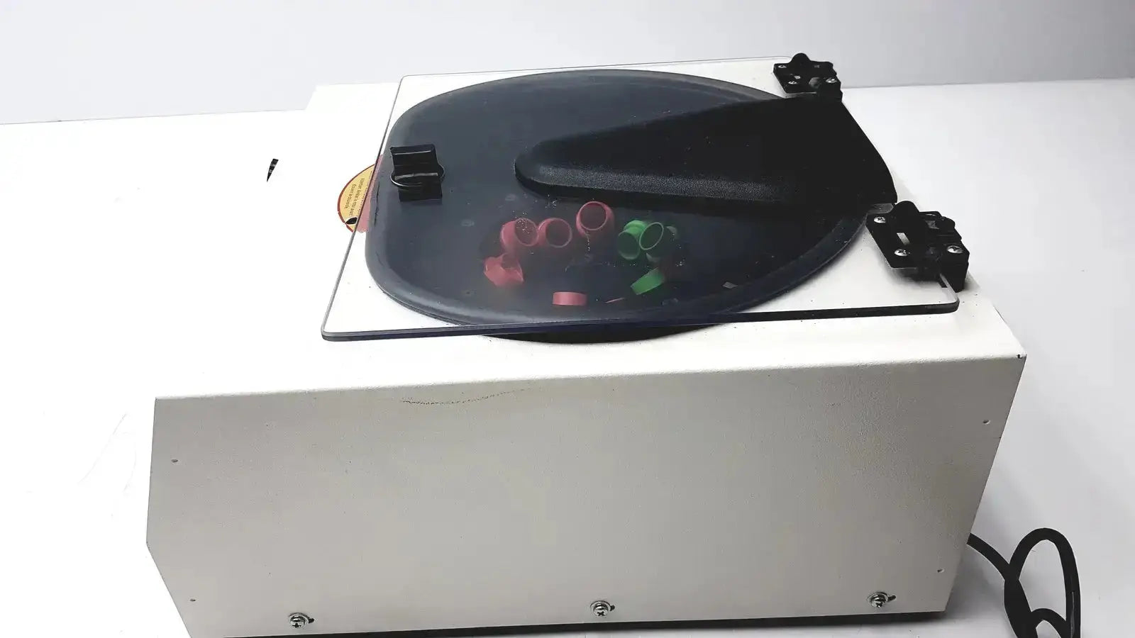 Drucker Horizon laboratory centrifuge 755v with white body and black rotating platform holding colorful test tubes for medical use