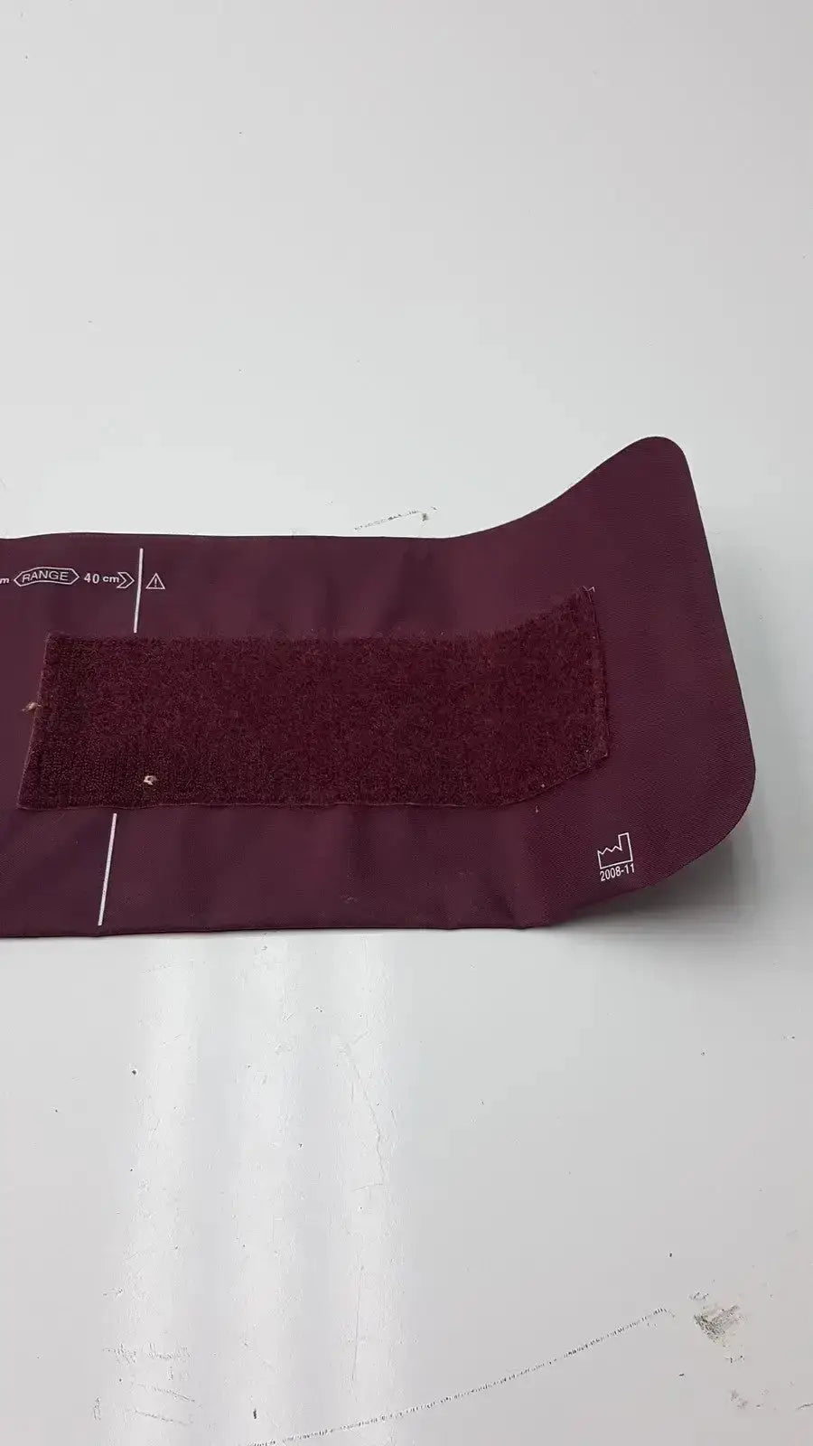 Maroon fabric Dura Cuff Critikon blood pressure cuff 2204 with velcro strap and printed measurement markings for accurate blood pressure monitoring