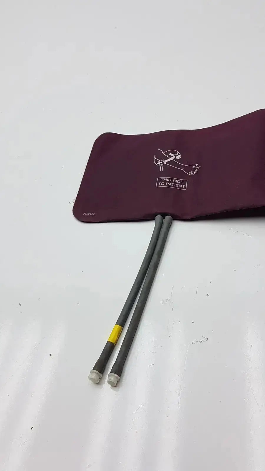 Dura cuff Critikon blood pressure cuff maroon with gray tubing and yellow connector bands for accurate blood pressure monitoring