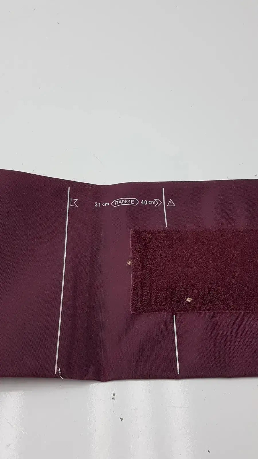 Dura cuff critikon blood pressure cuff 2204 in maroon fabric with white measurement markings and velcro strap for accurate blood pressure monitoring