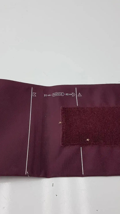 Dura cuff critikon blood pressure cuff 2204 in maroon fabric with white measurement markings and velcro strap for accurate blood pressure monitoring