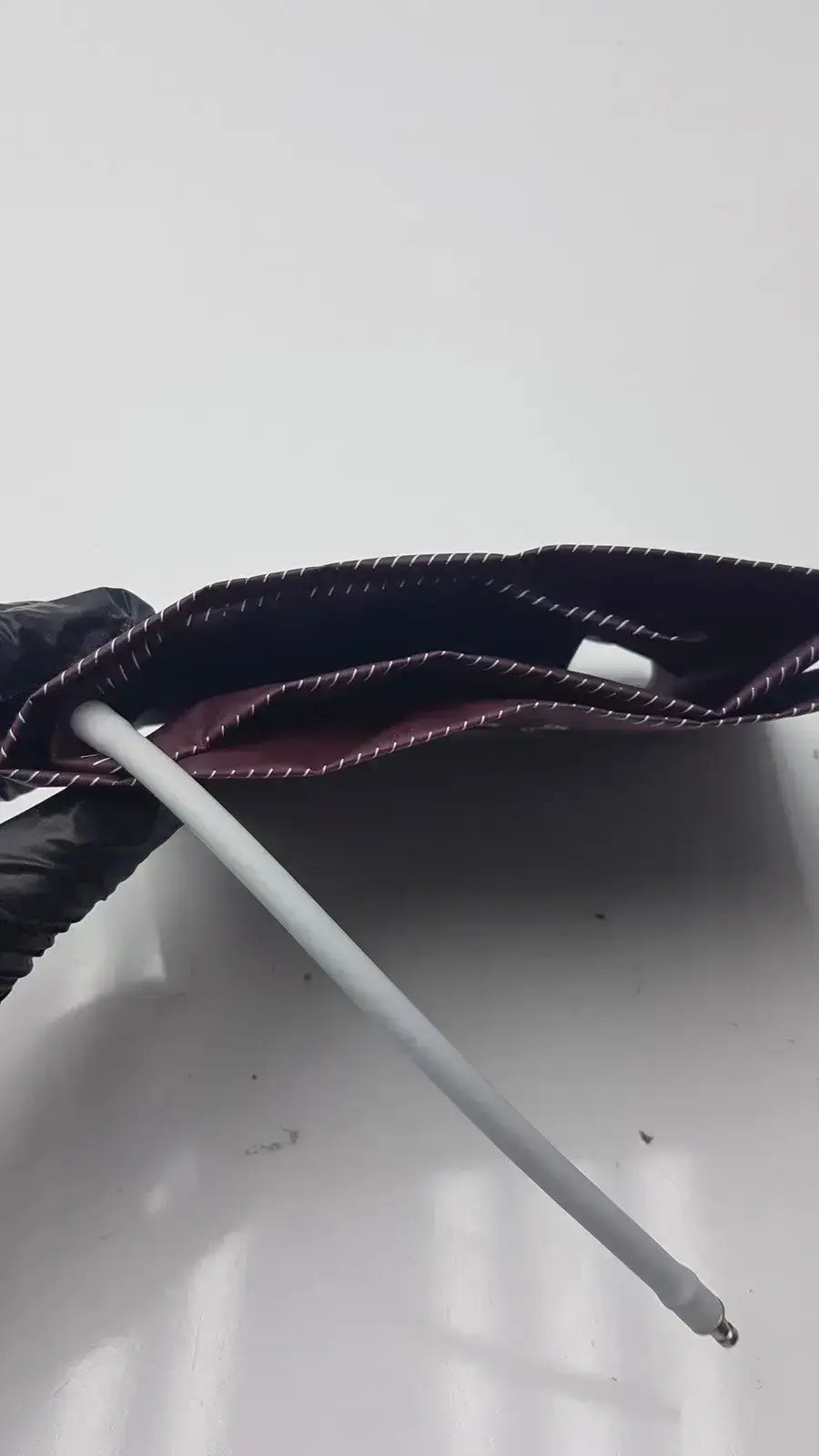 Dura Cuff Critikon blood pressure cuff model 2204 featuring a dark maroon fabric pressure cuff with white stitching and metal rod
