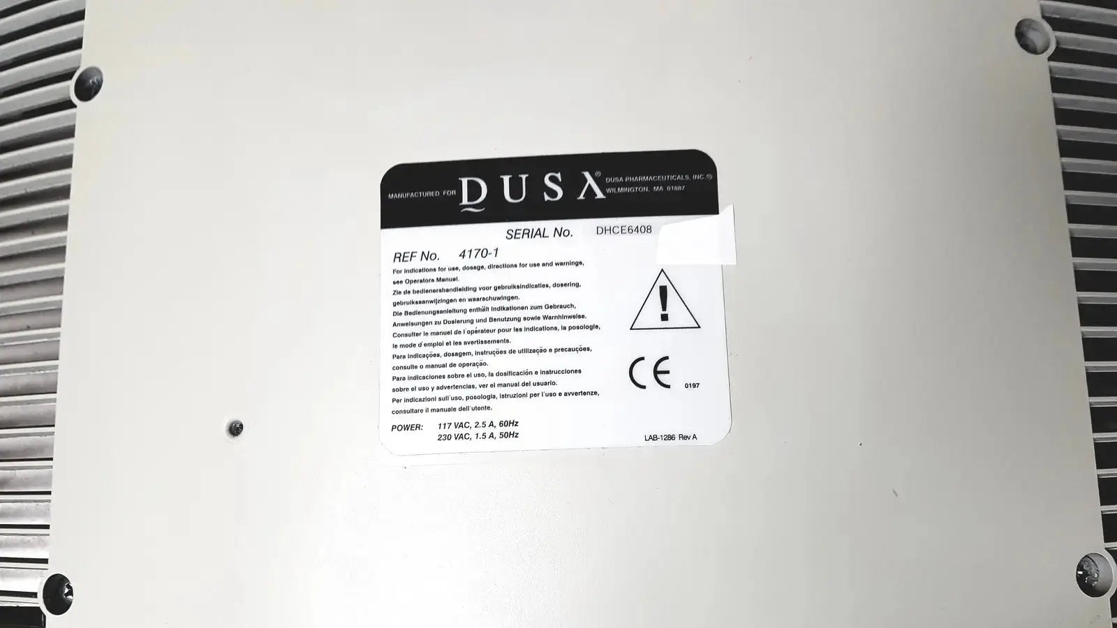 White rectangular label with black text and warning symbol on the back of dusa blu blue light photodynamic therapy system