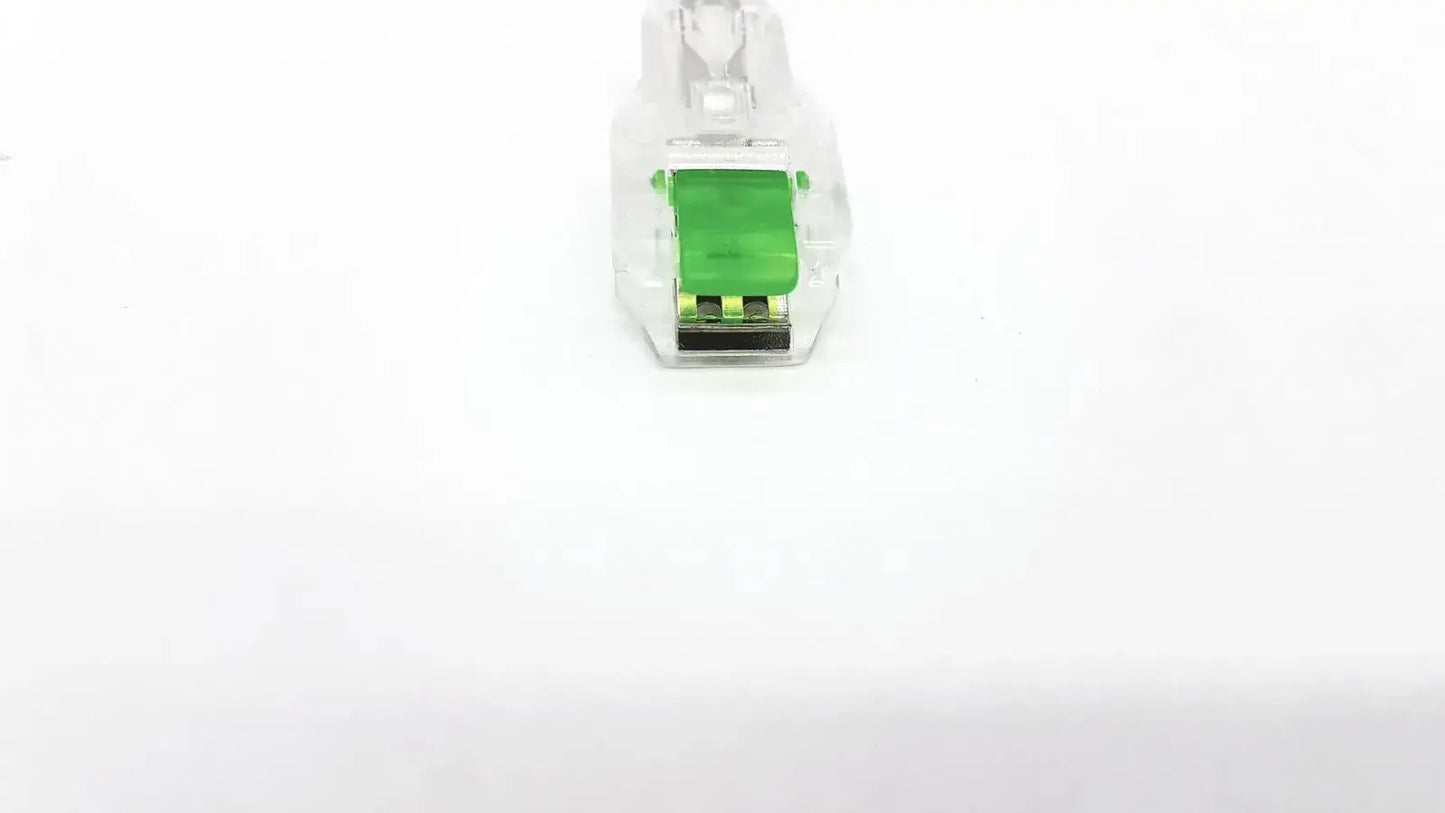 Clear plastic ecg adapter clip with green internal component and black contacts for medical connection use