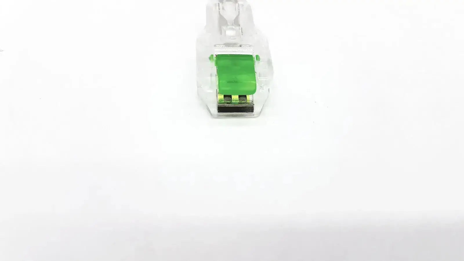 Clear plastic ecg adapter clip with green internal component and black contacts for medical connection use
