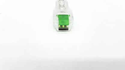 Clear plastic ecg adapter clip with green internal component and black contacts for medical connection use
