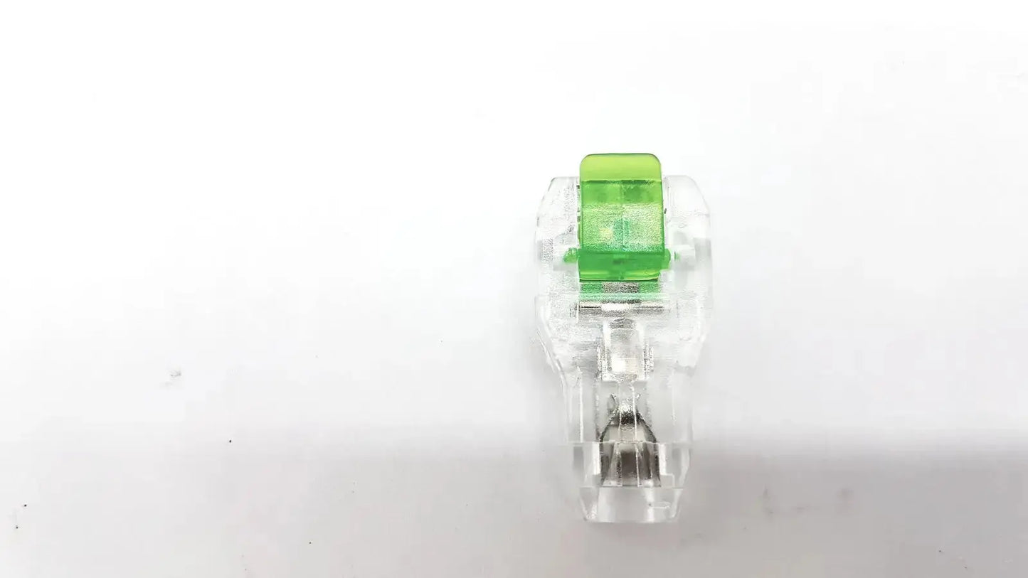 Clear plastic ecg adapter clip with bright green top cap for reliable electrical connection in medical devices
