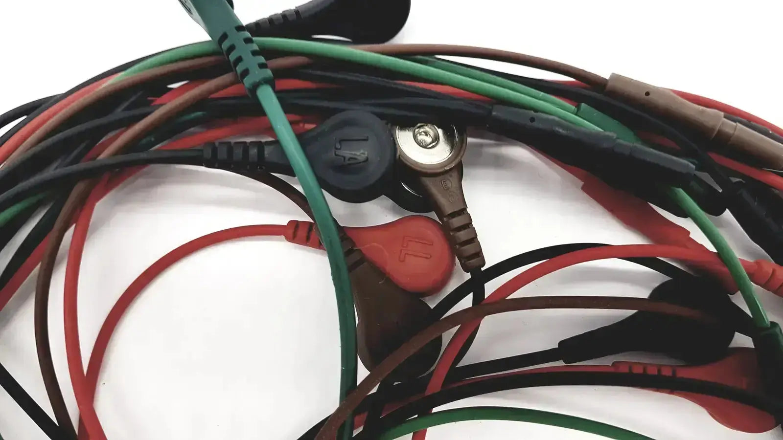 Tangle of red green black and brown medical-grade ecg bedside monitor snap cable lead wires with plastic connectors