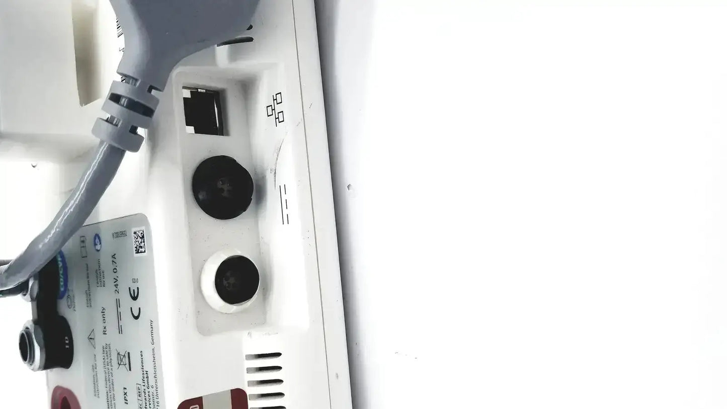 Back side of edwards lifesciences ev1000 databox with gray power cord plugged into white device with black and white circular ports
