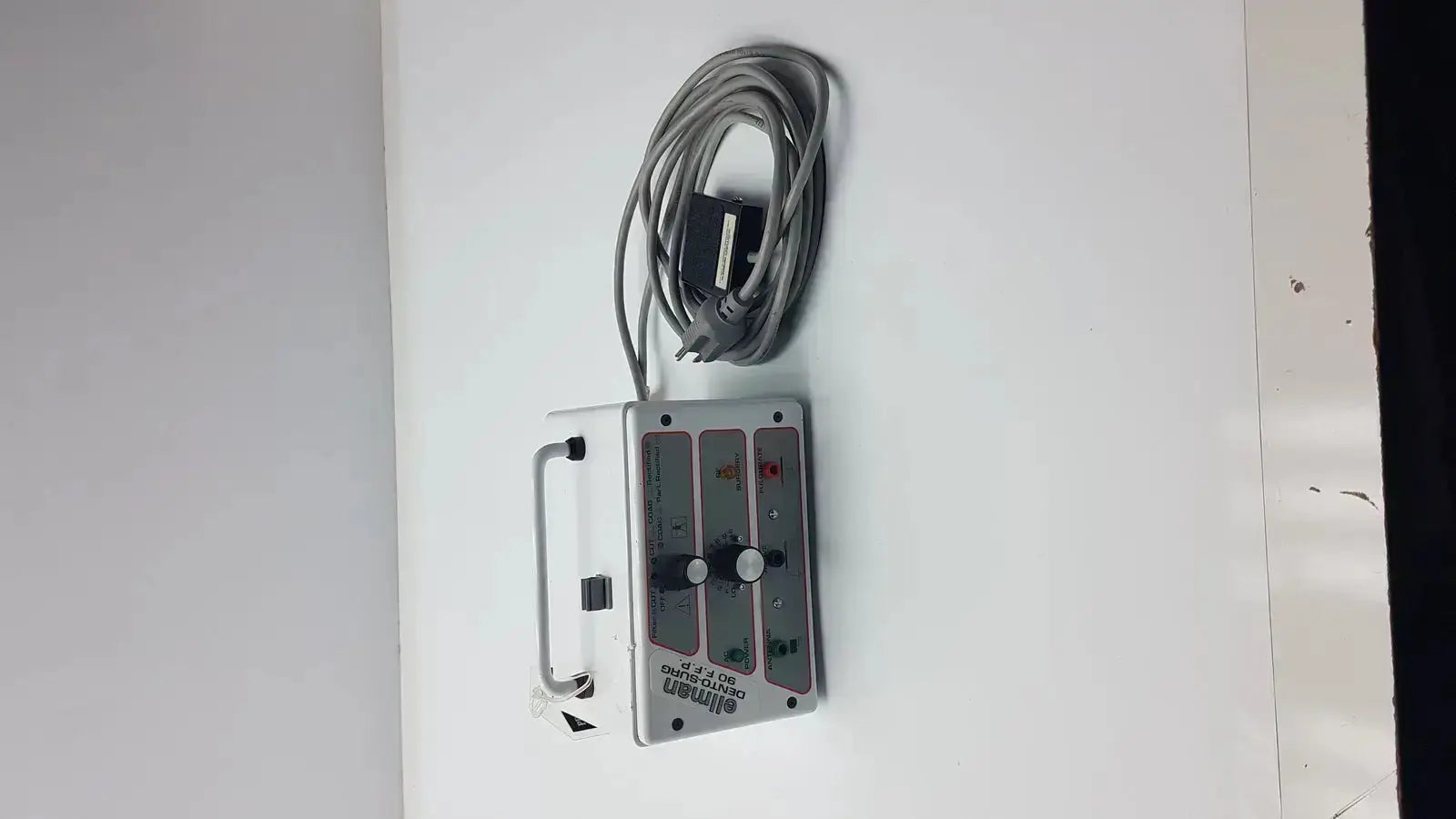 Silver aluminum industrial control panel with coiled gray cable and labeled switches for patient ready ellman dento surg