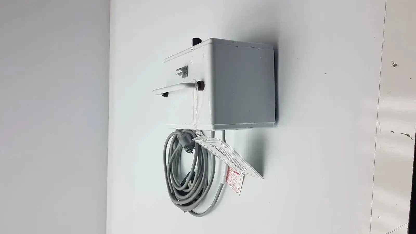 Gray rectangular electrical outlet box with coiled power cord attached showing back side of patient ready ellman dento surg device