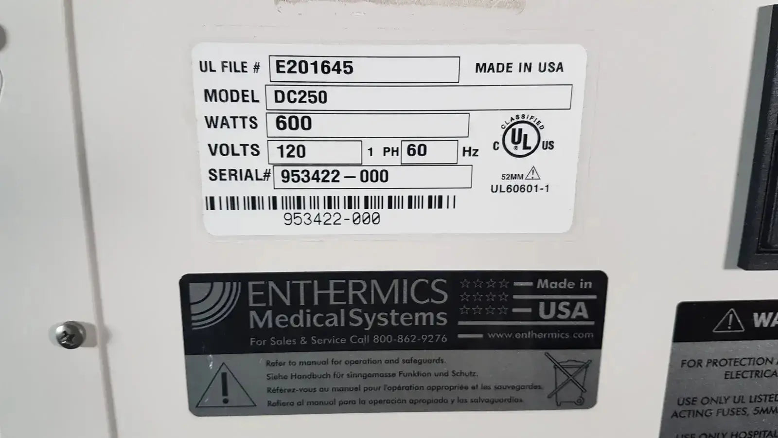 White rectangular label on the back of enthermics dc250 blanket warming cabinet showing model wattage and serial number