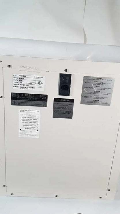 White enthermics enthermics blanket warming cabinet DC250 with black power plug and multiple warning labels on back side
