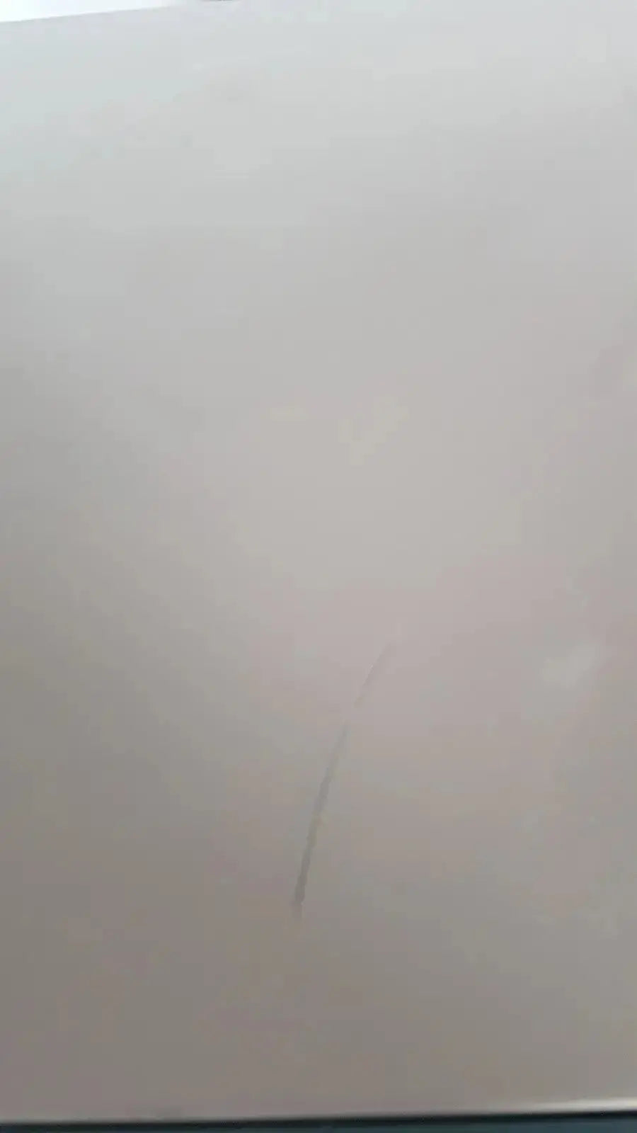 A faint thin vertical scratch on the smooth white surface of the enthermics blanket warming cabinet dc250