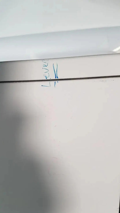 White wall with blue handwritten text and dark line on the back of enthermics blanket warming cabinet dc250