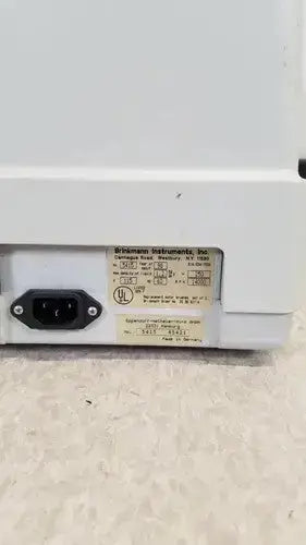 White plastic power supply unit with black ac input plug and label on the back of eppendorf centrifuge 5415c