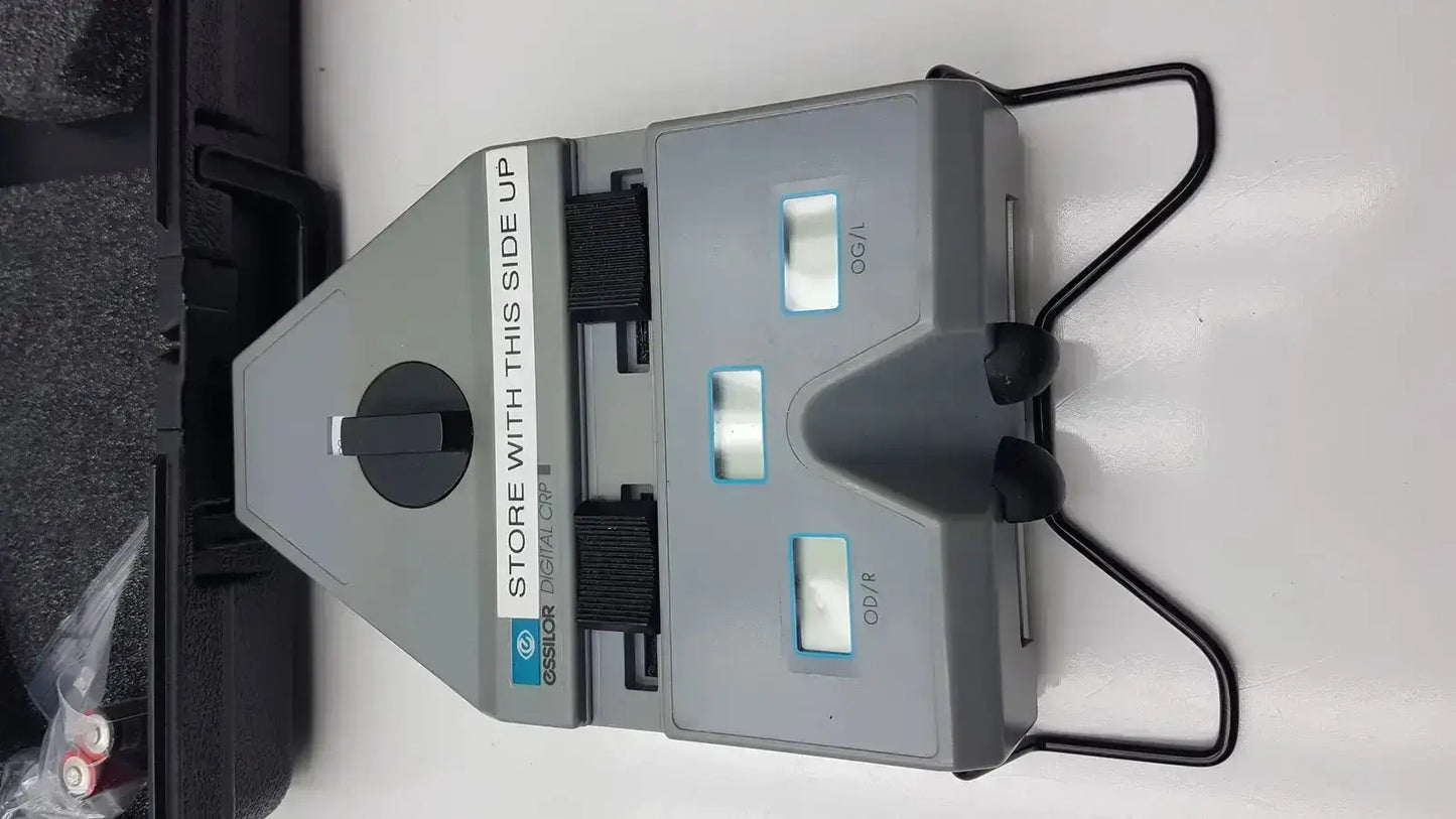 Gray plastic Essilor X81701 precision digital crp corneal reflection pupilometer with black handles and three illuminated displays