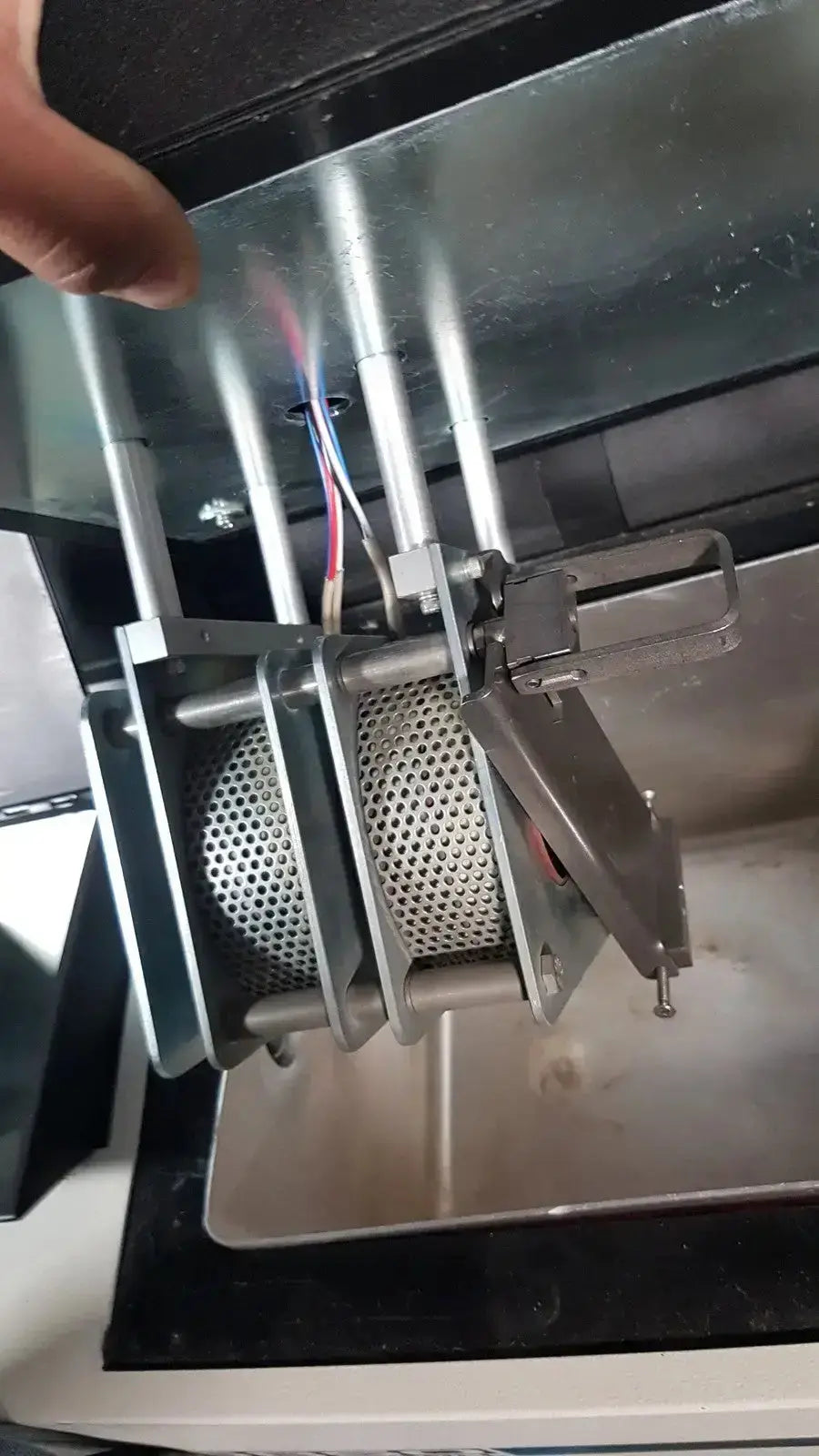 Silver metallic mesh cylinder with perforated surface and mechanical clamps in excellent spex 6850 freezer mill for biomedical evaluation and hospital surplus use
