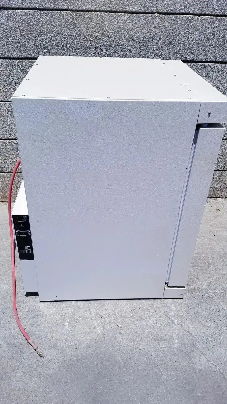 White industrial-grade metal electrical enclosure with mounting screws on the Fisher Scientific CO2 incubator 116885H