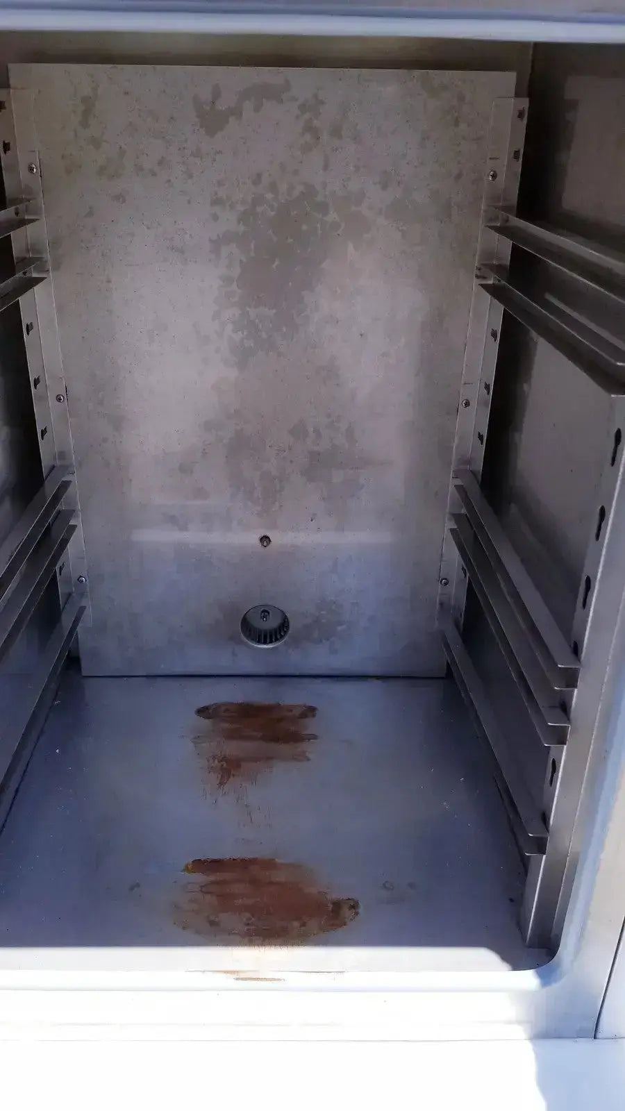 Interior of a stainless steel Fisher Scientific CO2 incubator 116885H showing rust stains on floor and walls